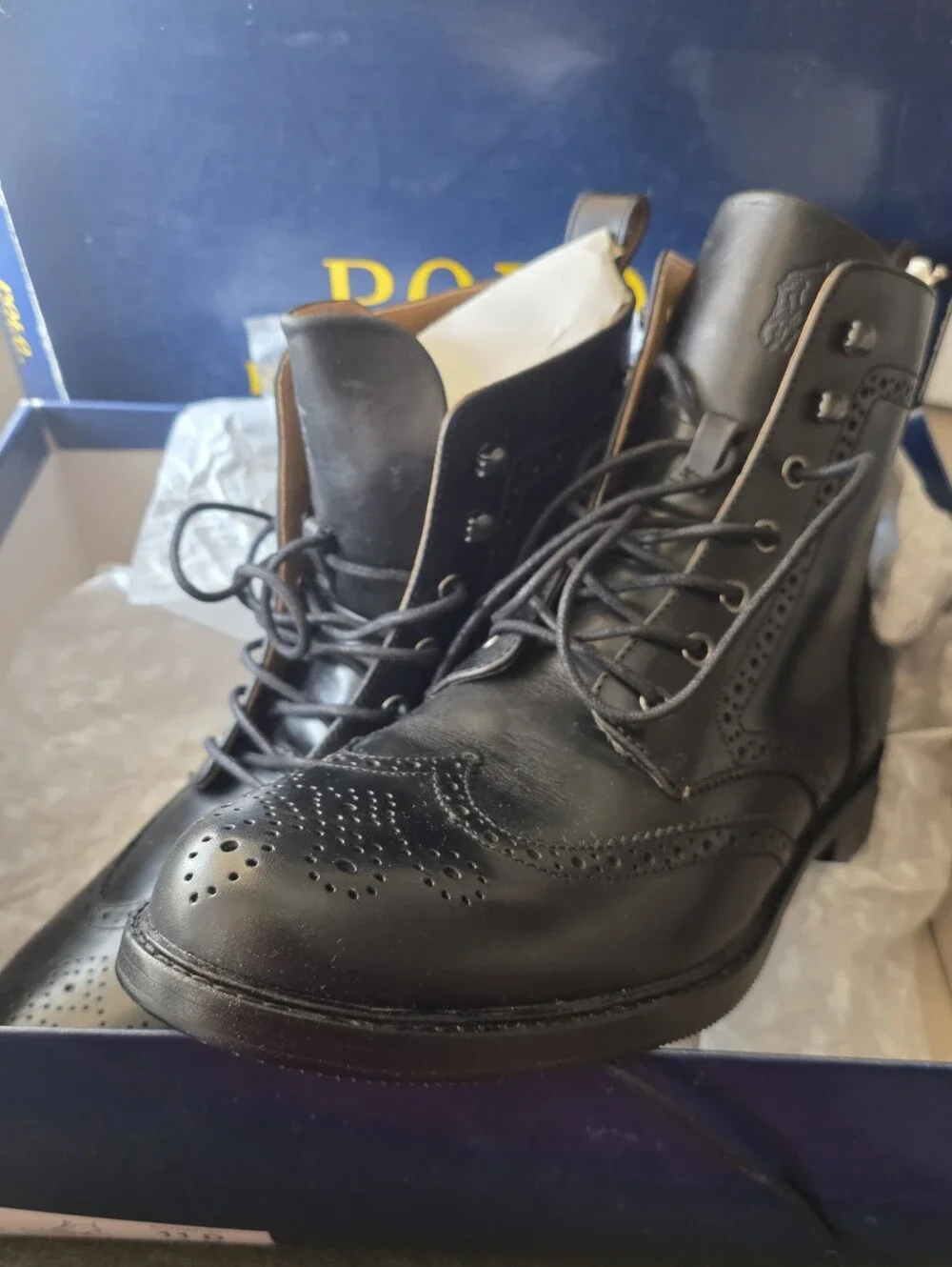 Polo Ralph Lauren lace-up leather boots feature classic wingtip brogue detailing